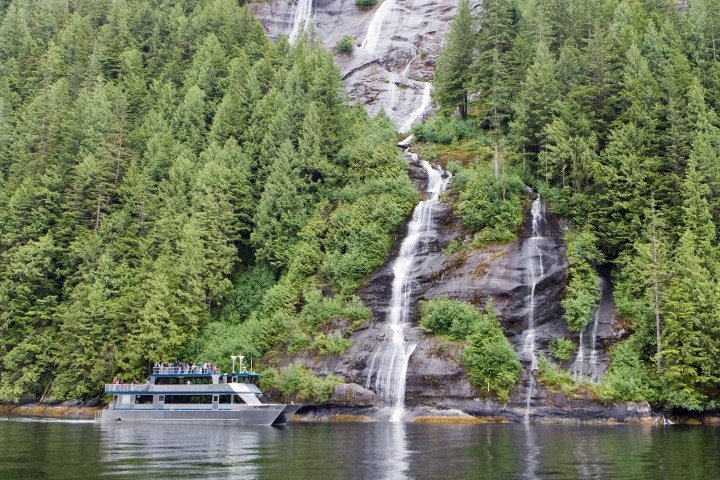 a boat traveling along a river next to a body of water