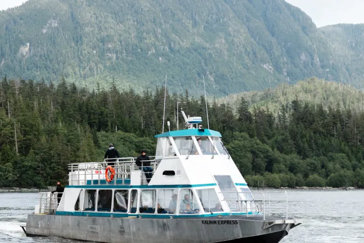 a small boat in a body of water with a mountain in the background