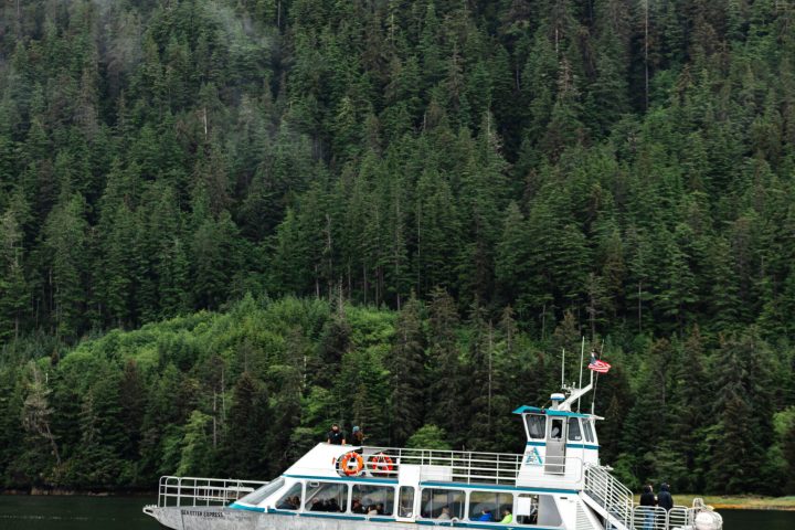 a boat traveling across a lake next to a body of water