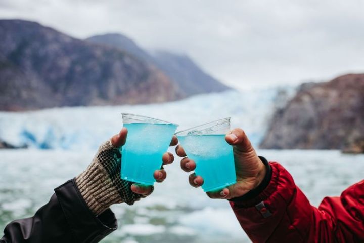 hand holding drink in front of glacier