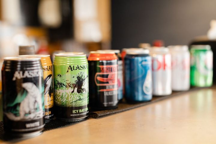 Various colorful beverage cans lined up on a counter in a row.