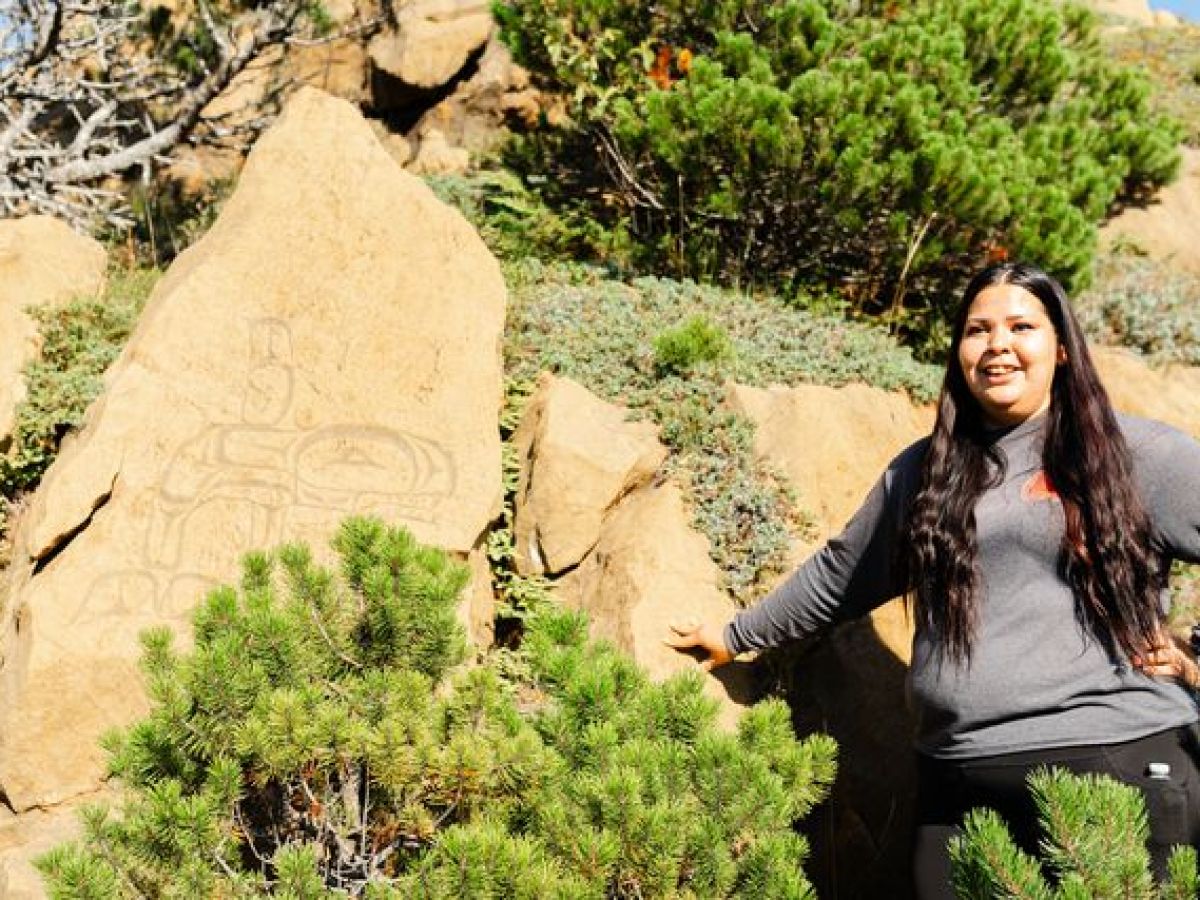 a person standing in front of a large rock