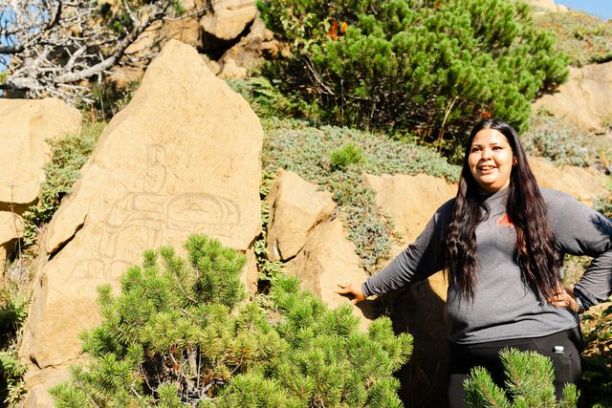 a person standing in front of a large rock