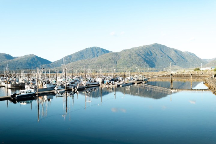 a small boat in a body of water with a mountain in the background